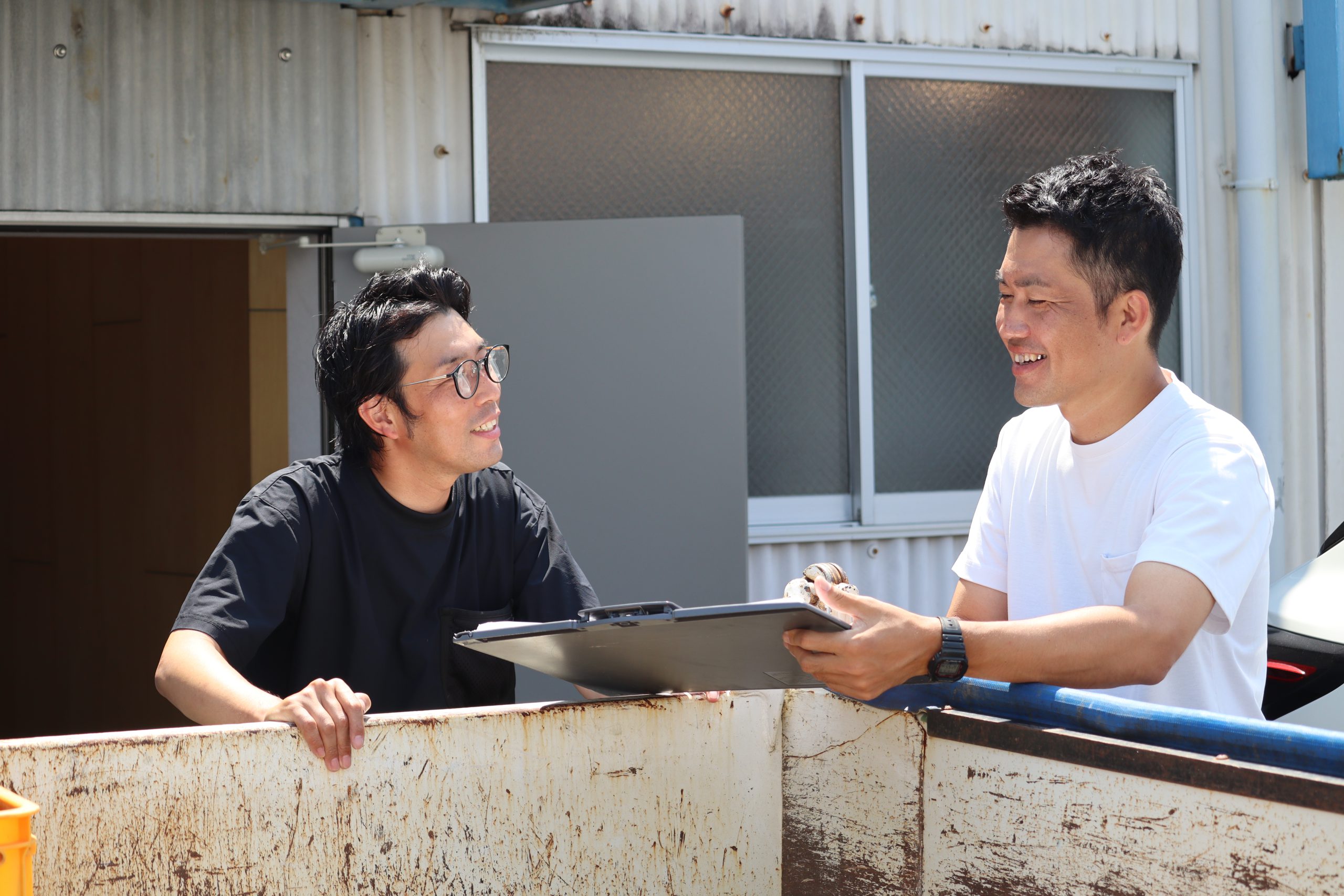 屋外で仕事について話す熊本建設のスタッフ